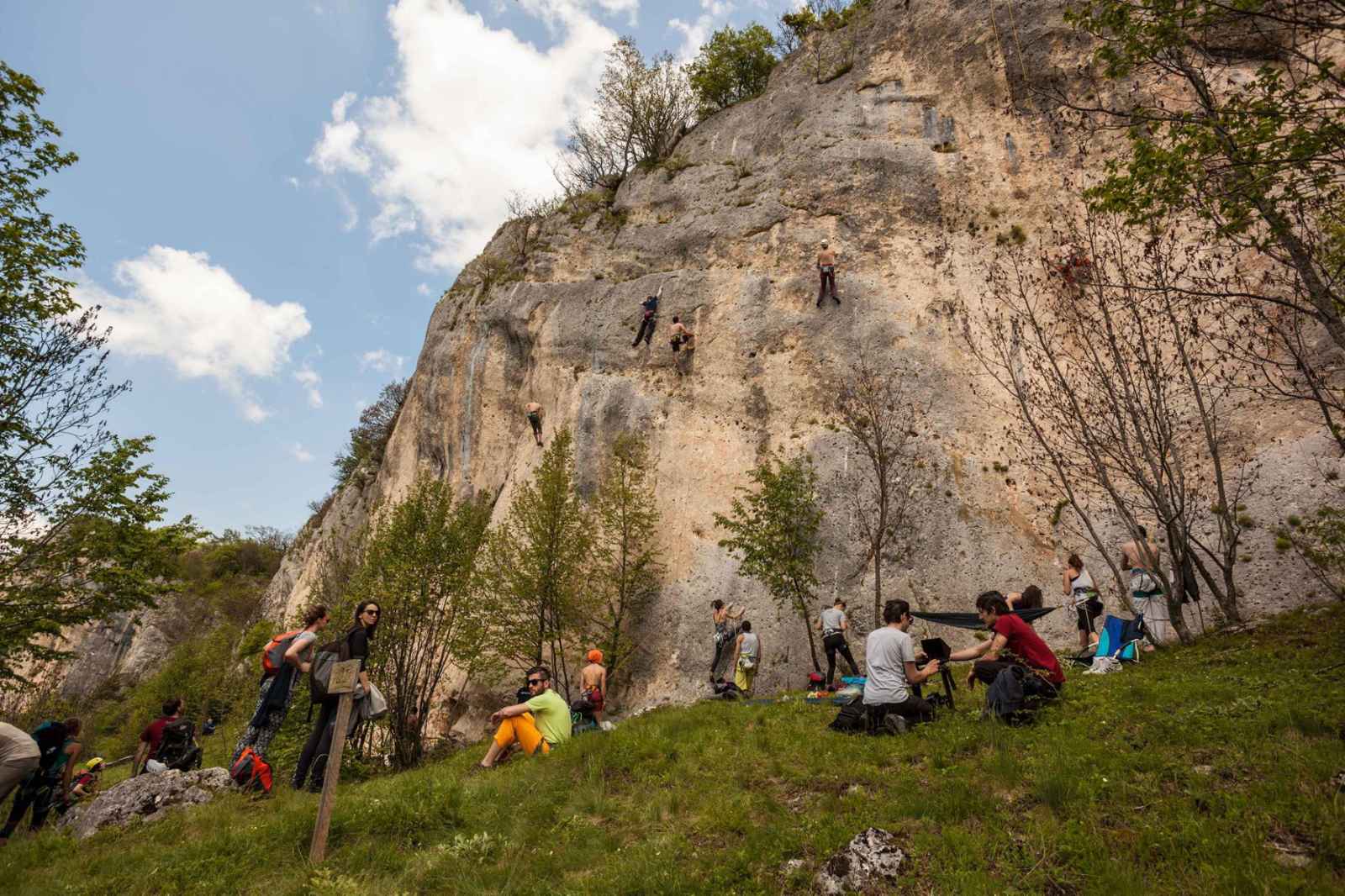 Grupa penjača i posjetilaca podno krečnjačke stijene u Peckoj
