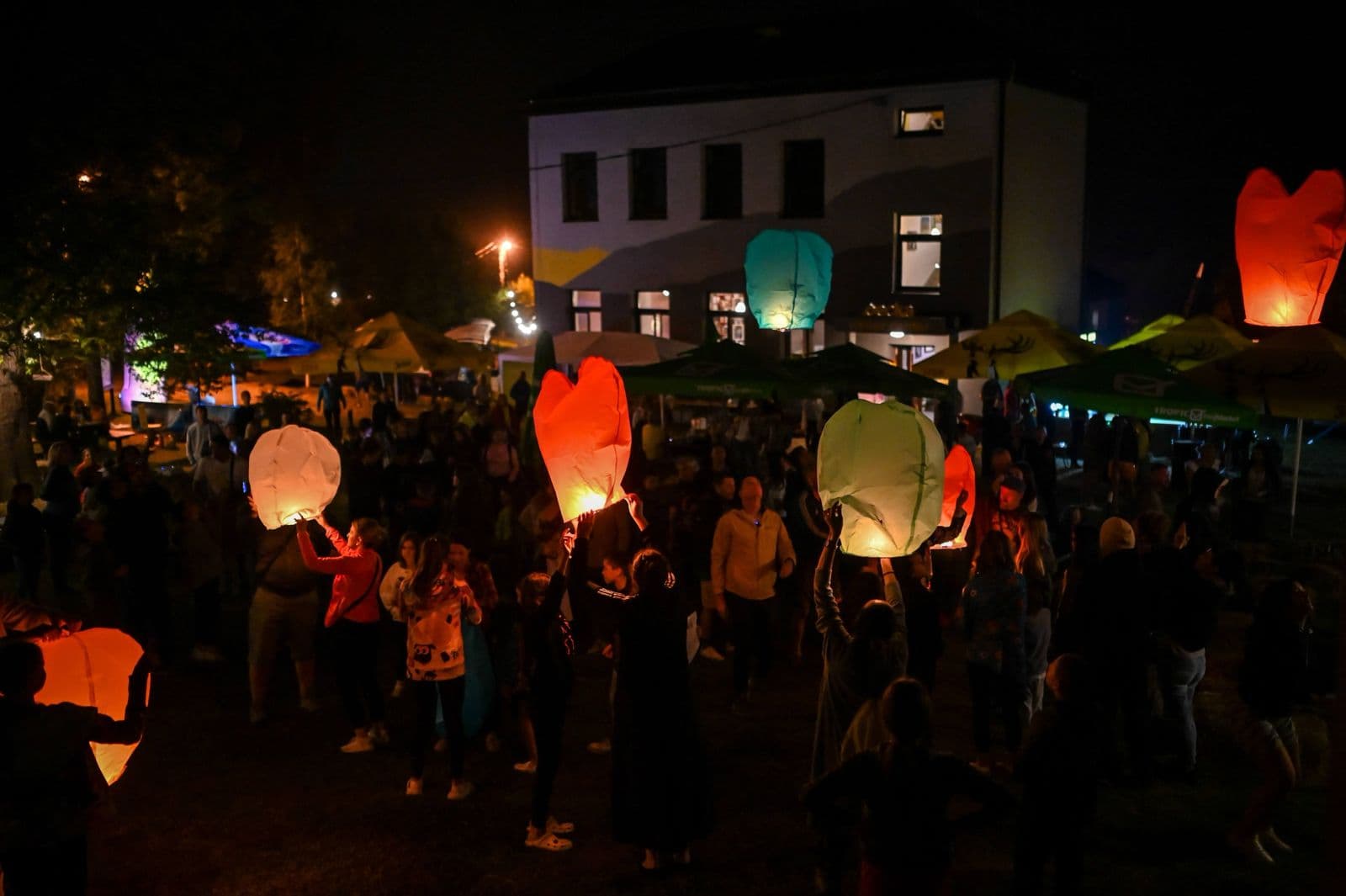 Lampioni lete iznad posjetilaca ispred stare škole tokom Pecka Outdoor Festivala