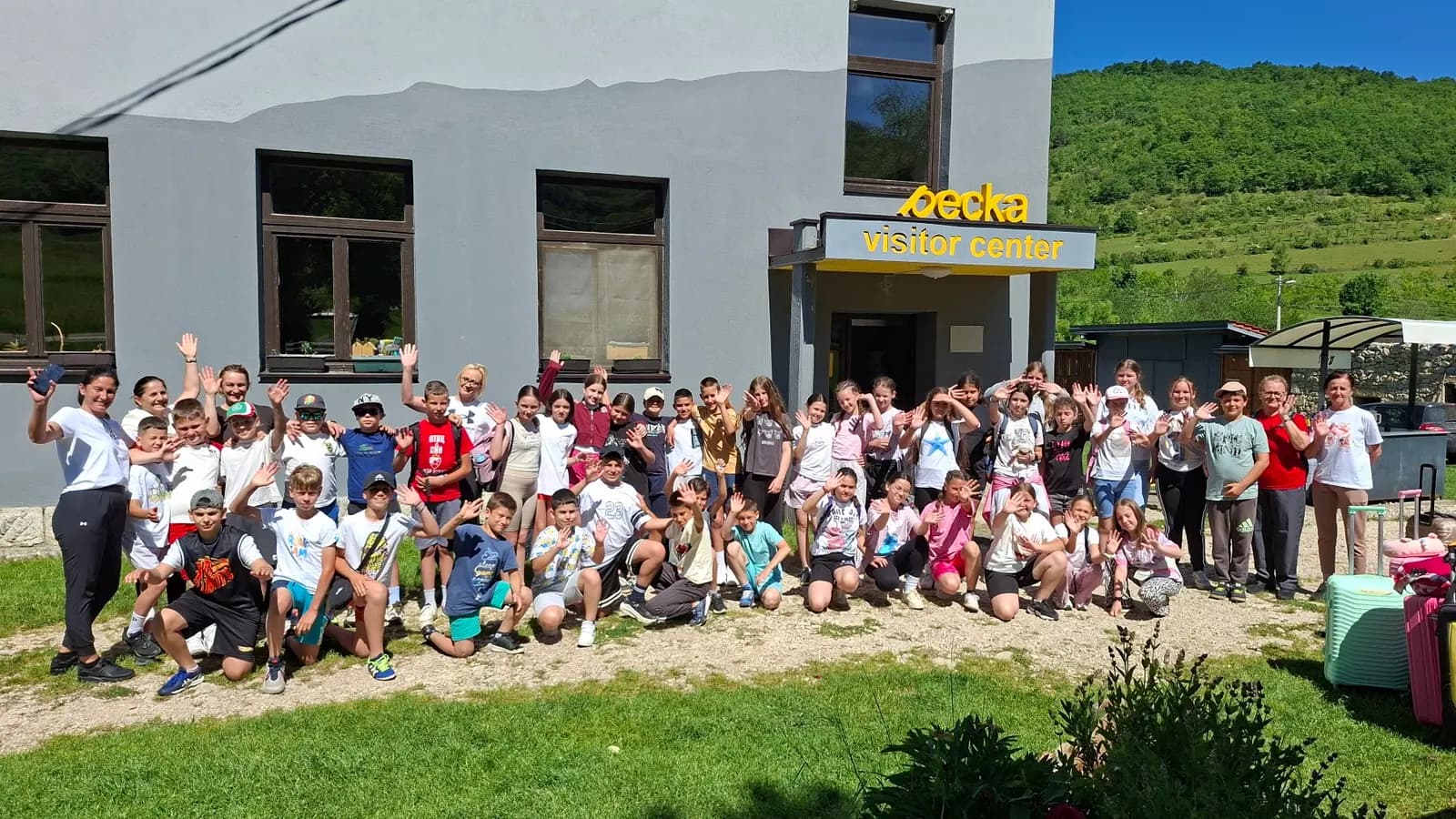 Učenici i nastavnici mašu ispred zgrade Visitor centra Pecka na dan dolaska